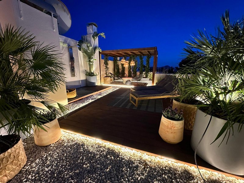 Terraza ajardinada con iluminación nocturna